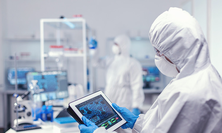 concentrated-medical-researcher-using-digital-tablet-dressed-protective-suit-conducting-vaccine-development-using-high-tech-technology-750px