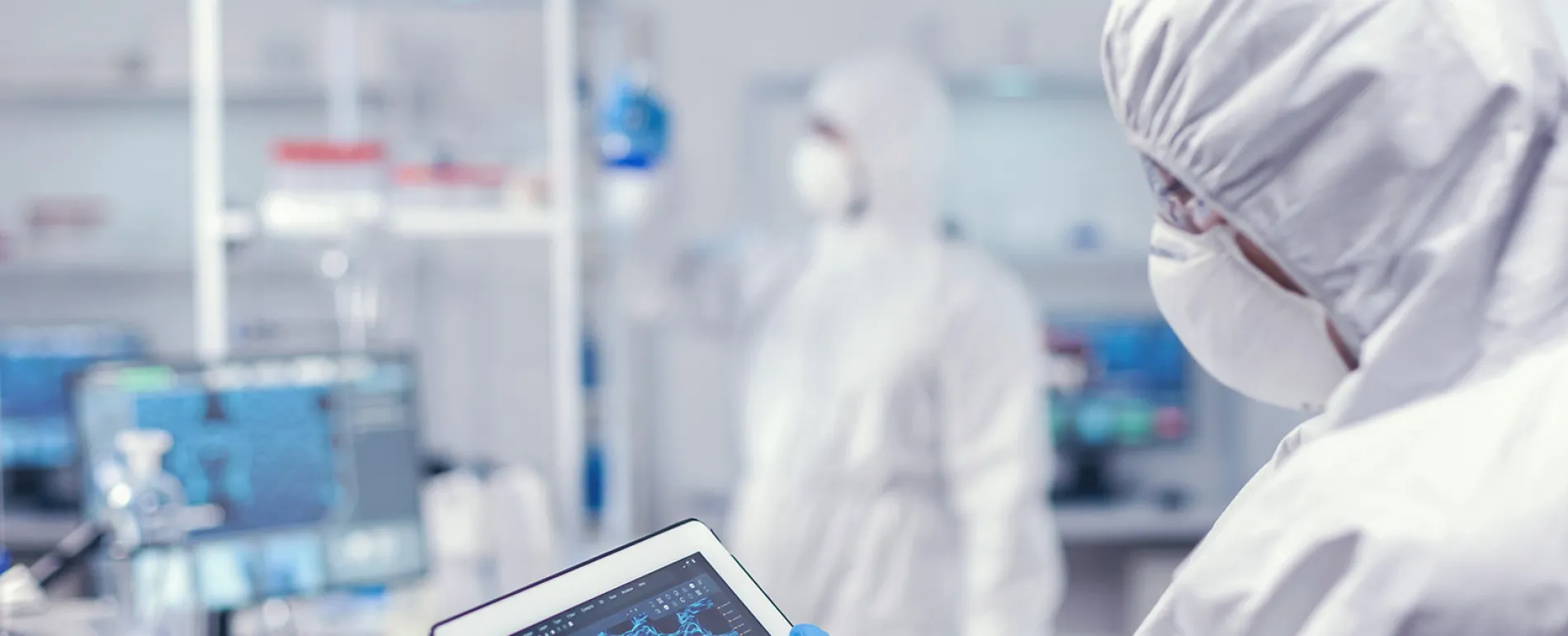 medical-researcher-using-digital-tablet-dressed-protective-suit-conducting-vaccine-development-using-high-tech-technology-1900px.jpg