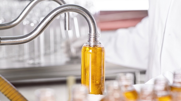 factory-worker-white-gown-rubber-gloves-holding-plastic-bottle
