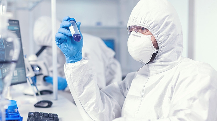 lab-technician-dressed-protective-suit-as-safety-precaution-looking-test-tube