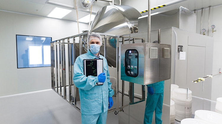 Scientist-near-big-steel-machine-with-control-panel-aseptic-750px
