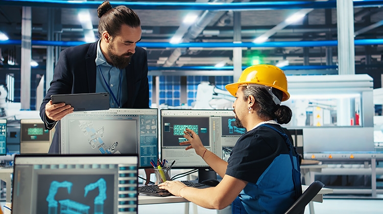 factory-engineer-shows-manager-facility-plans-750px