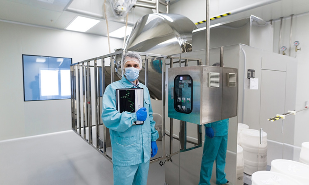 Scientist-near-big-steel-machine-with-control-panel-aseptic-750px