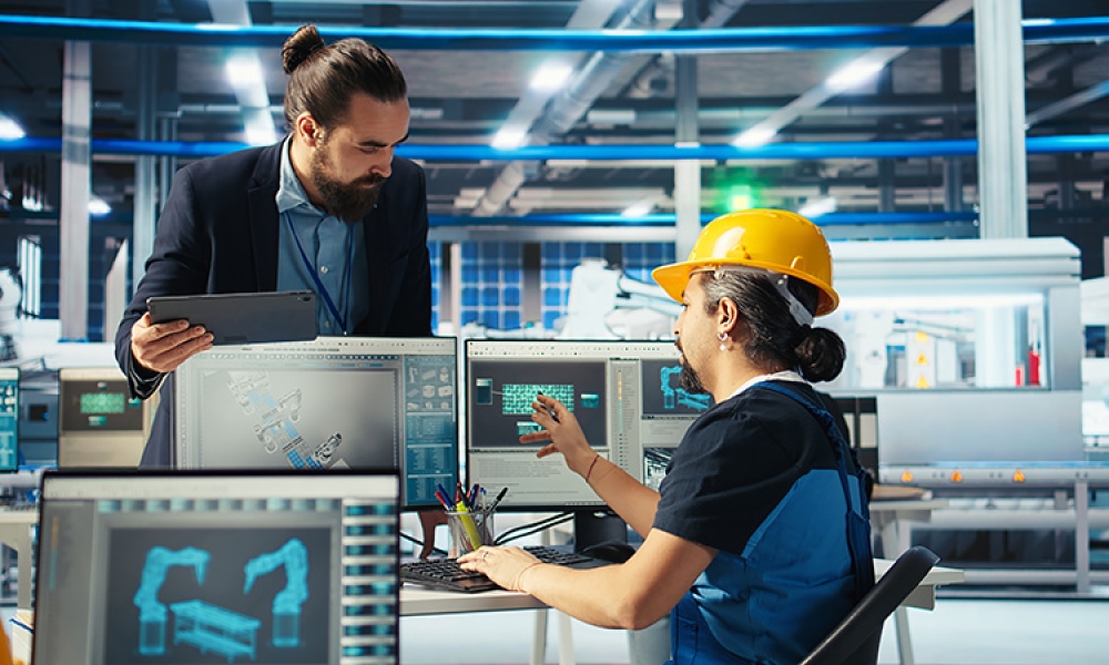 factory-engineer-shows-manager-facility-plans-750px