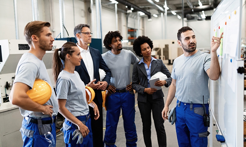 worker-presenting-results-business-development-to-team-factory-750px.jpg